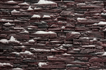 Stone wall covered with snow