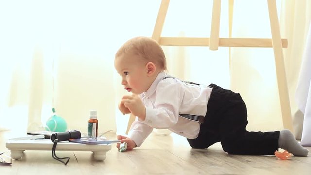 Little baby in costume is played on the floor