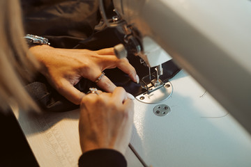 Woman tailor hands working on sewing machine.