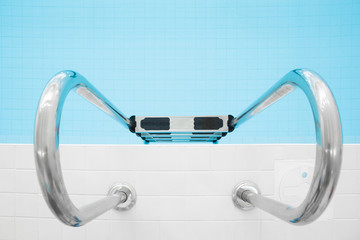 Metallic ladder in swimming pool. Closeup.
