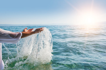 Obraz na płótnie Canvas Woman hands splashing sea water. Holidays at the resort concept.