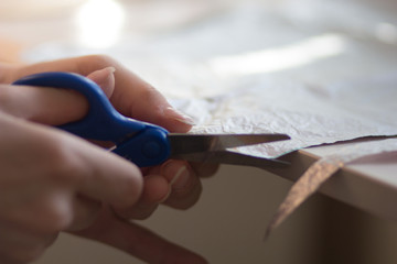 woman hands cutting paper material with scissors