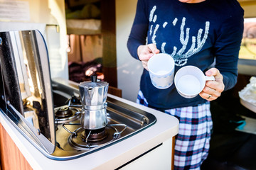 Cooking coffee in campervan, caravan or RV on camping trip.