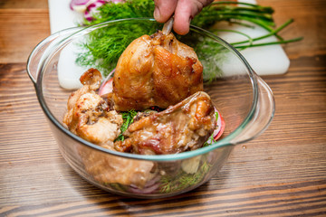 Roasted rabbit with herbs, tomato sauce and glass of wine on a plate.