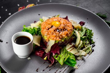 A Tartar dish on black wooden baclground