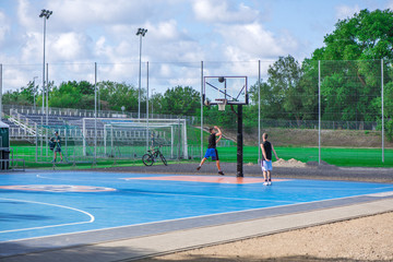 Abstract, blurry background of boys playing basketball in outdoor basketball court in park  