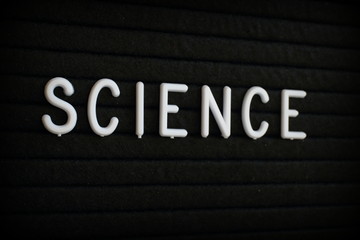 The word Science in white plastic letters on a black letter board