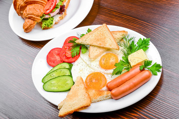 fried eggs with bacon, sausages and toasts
