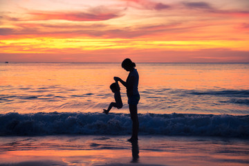 Silhouette mother and child on sunset in a happy family day