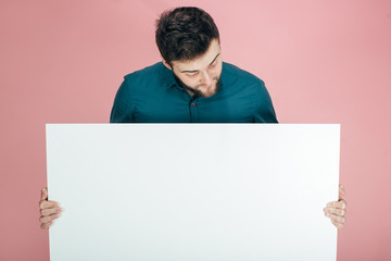 young man cheerful and motivated, showing an empty poster where you can show a message, communication concept