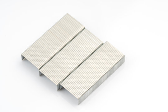 Stapler and metal staple concept over white background