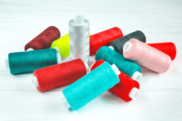 Many colorful threads lying on white table