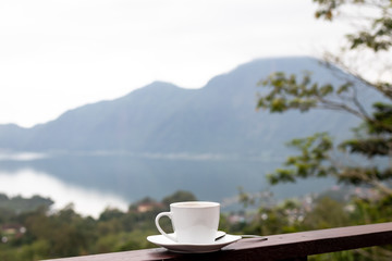White cup of hot coffee on nature background. Bali island. Volcano Batur.