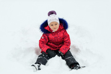 Fototapeta na wymiar a girl plays in the snow in winter
