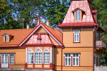 Beautiful summer house next to the forest. Wooden cottage with small towers and decorative elements. Concept of luxury lifestyle and architectural masterpiece. 