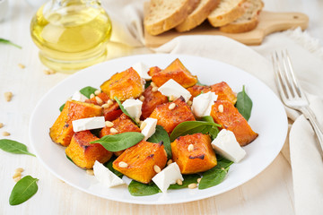 Salad with roasted pumpkin, feta cheese, spinach, nuts with honey and seasonings, side view