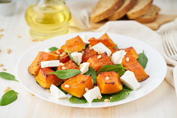 Salad with roasted pumpkin, feta cheese, spinach, nuts with honey and seasonings, side view