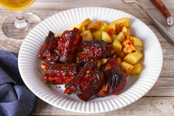 Grilled pork spare ribs with fries. Roasted sliced barbecue ribs