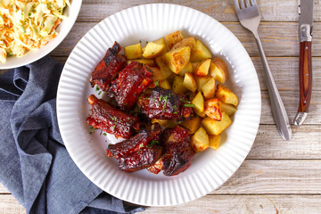 Grilled pork spare ribs with fries. Roasted sliced barbecue ribs. View from above, top studio shot, copy space