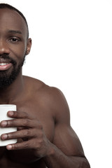 African man with white cup of tea or coffee, isolated on white studio background. Close up portrait in minimalism style of a young naked happy afro man - obrazy, fototapety, plakaty