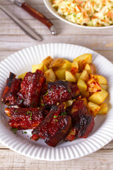 Grilled pork spare ribs with fries. Roasted sliced barbecue ribs
