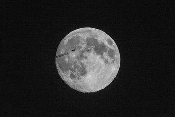Silhouette eines Flugzeugs vor einem Vollmond