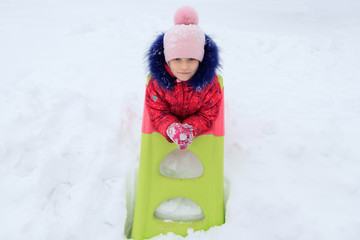 a girl plays in the snow in winter