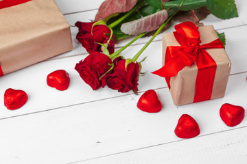 St. Valentines Day. Red roses and gift box on wooden table