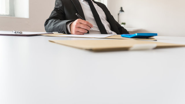Low angle view of business advisor or revisor sitting at his office desk working