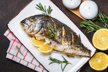 Baked dorado fish with lemon and rosemary.