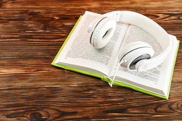 Electronic audiobook vs regular paper book concept. Stack of different color hardcover books with...