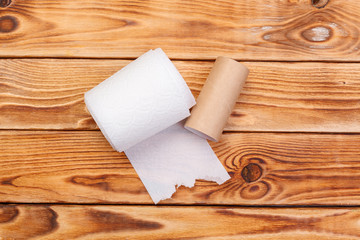 Torn toilet paper roll on a wooden background