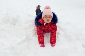 a girl plays in the snow in winter