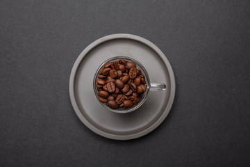 Obraz na płótnie Canvas Coffee cup and beans on black color background, top view