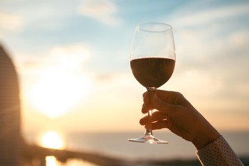 A glass of red wine at sunset.