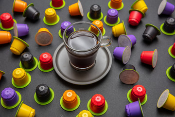 Coffee cup and compostable capsules, on black color background