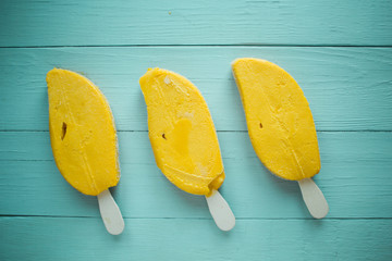 bright yellow ice cream on a blue table