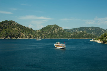 Fototapeta na wymiar pleasure boat in the bay near the mountains
