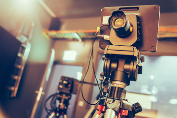 Modern film camera on a tripod in a broadcasting studio, spotlights and other equipment
