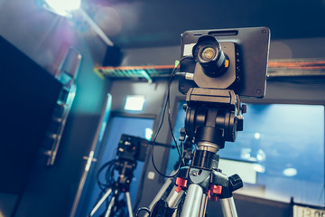 Modern film camera on a tripod in a broadcasting studio, spotlights and other equipment