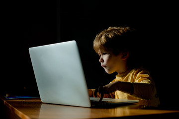 Technology. Computer user. The child looks with passion at the computer screen. Monitor, interest...