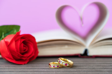 Pages of book curved  heart shape with wedding ring
