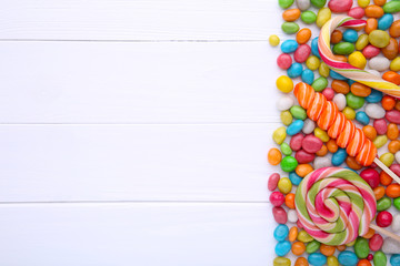Fototapeta na wymiar Colorful lollipops and different colored round candy on white background