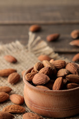 almond nut in a wooden bowl close-up on a napkin on a brown wooden table