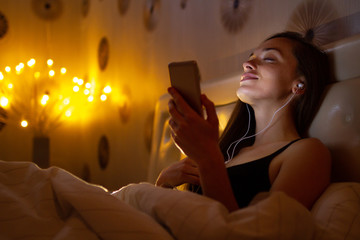 Young, attractive woman before bed listening and enjoying relaxing music after a hard, working day....