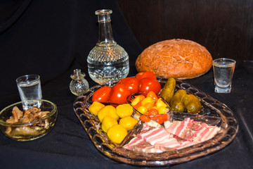 Tsarist still life luxury decanter of vodka and appetizer lard pickled cucumbers tomatoes pepper mushrooms black bread