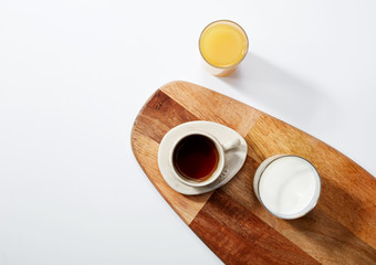 Three glasses of drinks over white background. Milk, orange juice and coffee