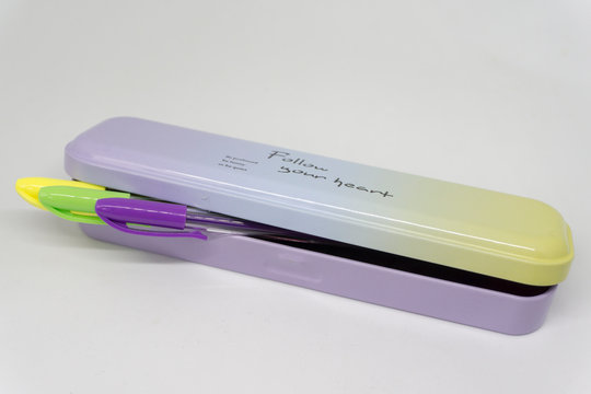 Estuche met&aacute;lico de colores con bol&iacute;grafos asomando 