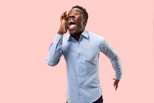 Do not miss. Young casual man shouting. Shout. Crying emotional man screaming on pink studio background. male half-length portrait. Human emotions, facial expression concept. Trendy colors