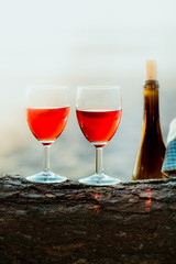 Two wine glasses and bottle of wine on beach